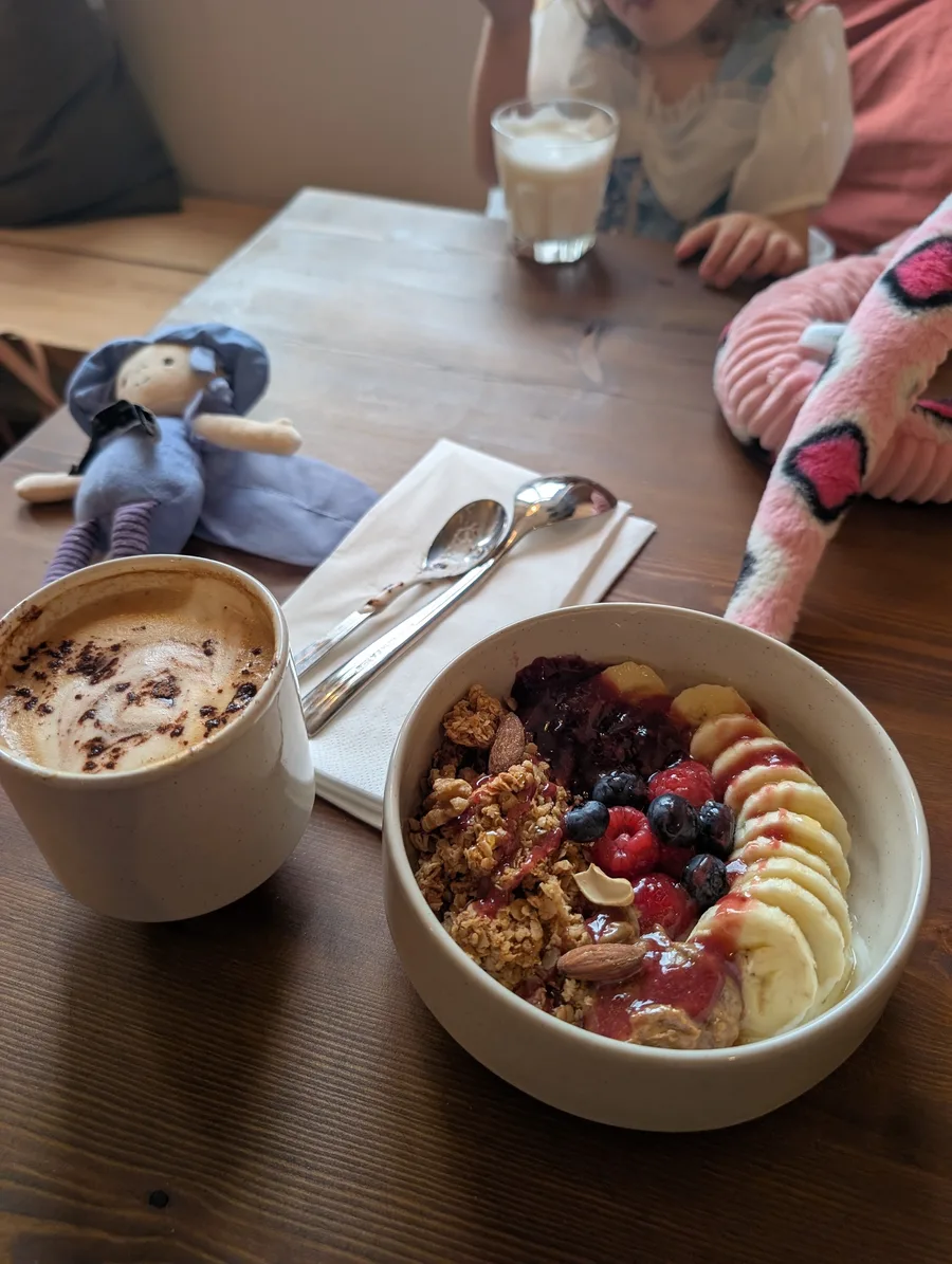 A fruit and granola bowl with a coffee at Rizia’s Bottega