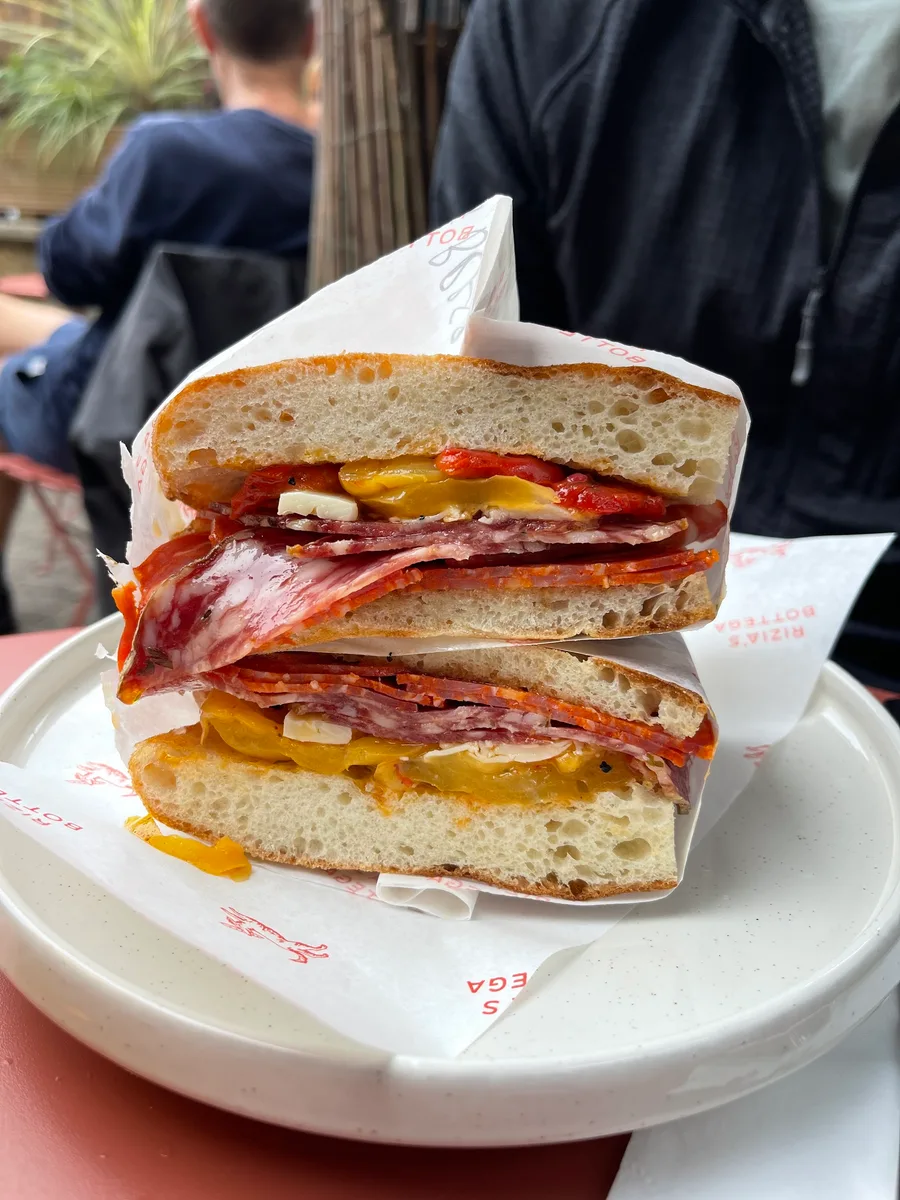 A freshly served schiacciata filled with Italian meats and cheese